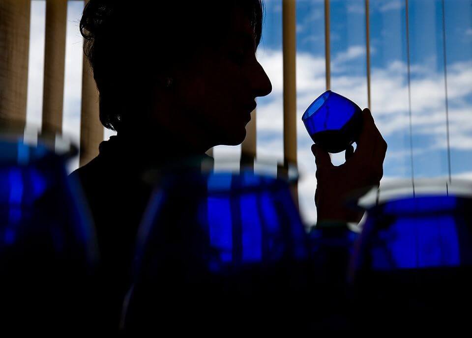 Vaso azul profesional de cata de aceite de oliva virgen extra en Riudecanyes sobre mesa rústica.